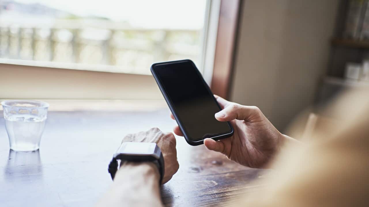 Man checking smartwatch and syncing smartwatch