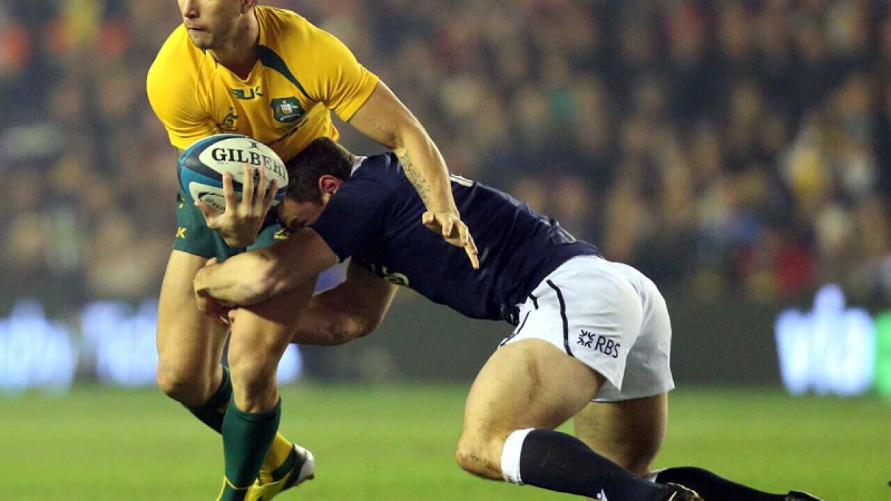 Australia's Quade Cooper, left, is tackled by Scotland's Sean Maitland