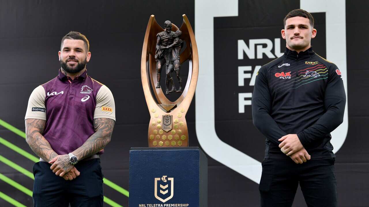 Adam Reynolds of the Broncos (left) and Nathan Cleary of the Panthers pose alongside the Provan-Summons Trophy during the NRL grand final fan fest at The Rocks in Sydney