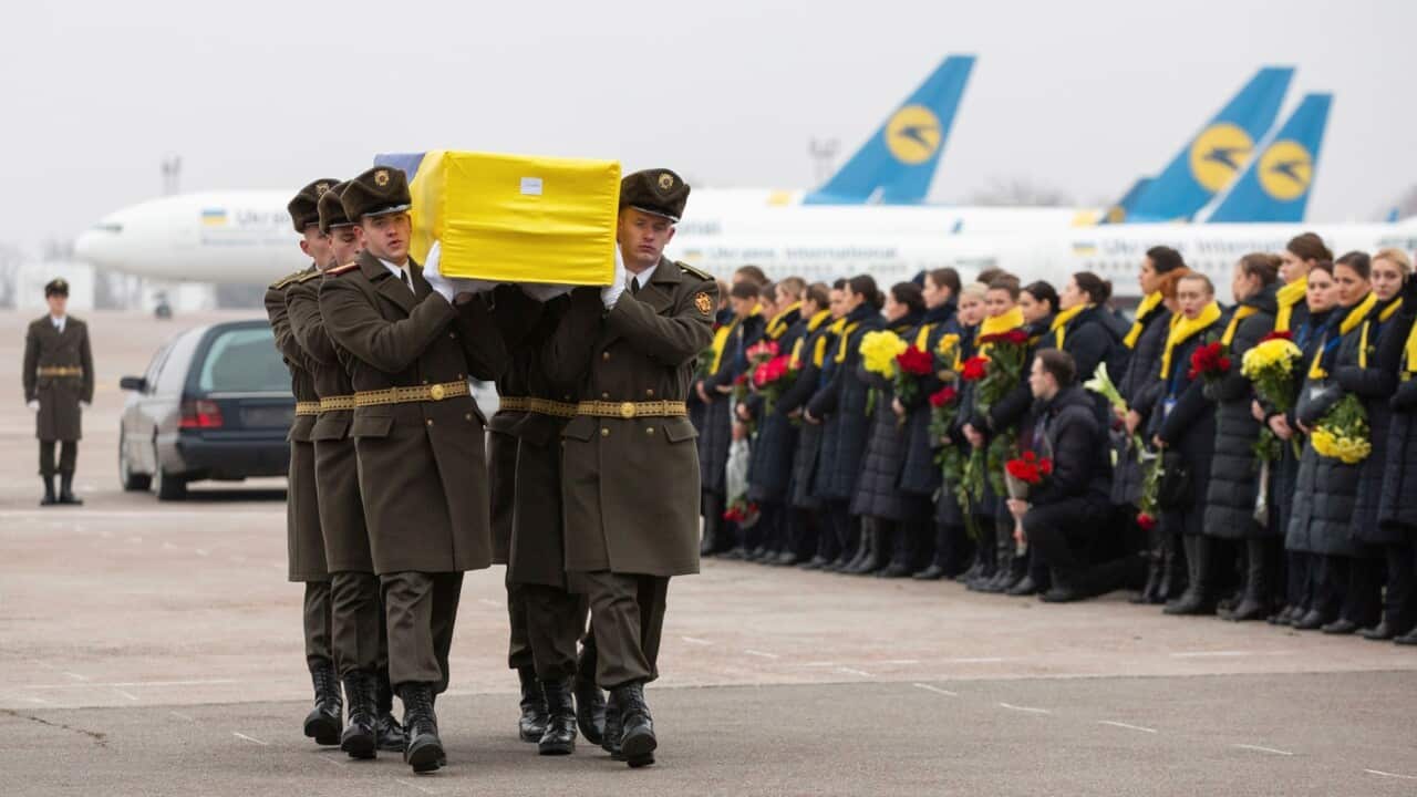 An honour guard carries a coffin of the one of the Ukrainian victims of the plane that crashed in Iran