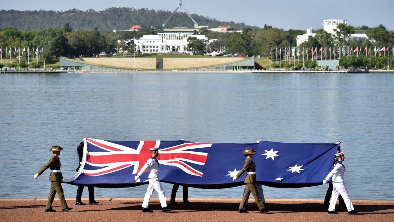 Marcia con la bandiera australiana alla Cerimonia per la Cittadinanza a Canberra.