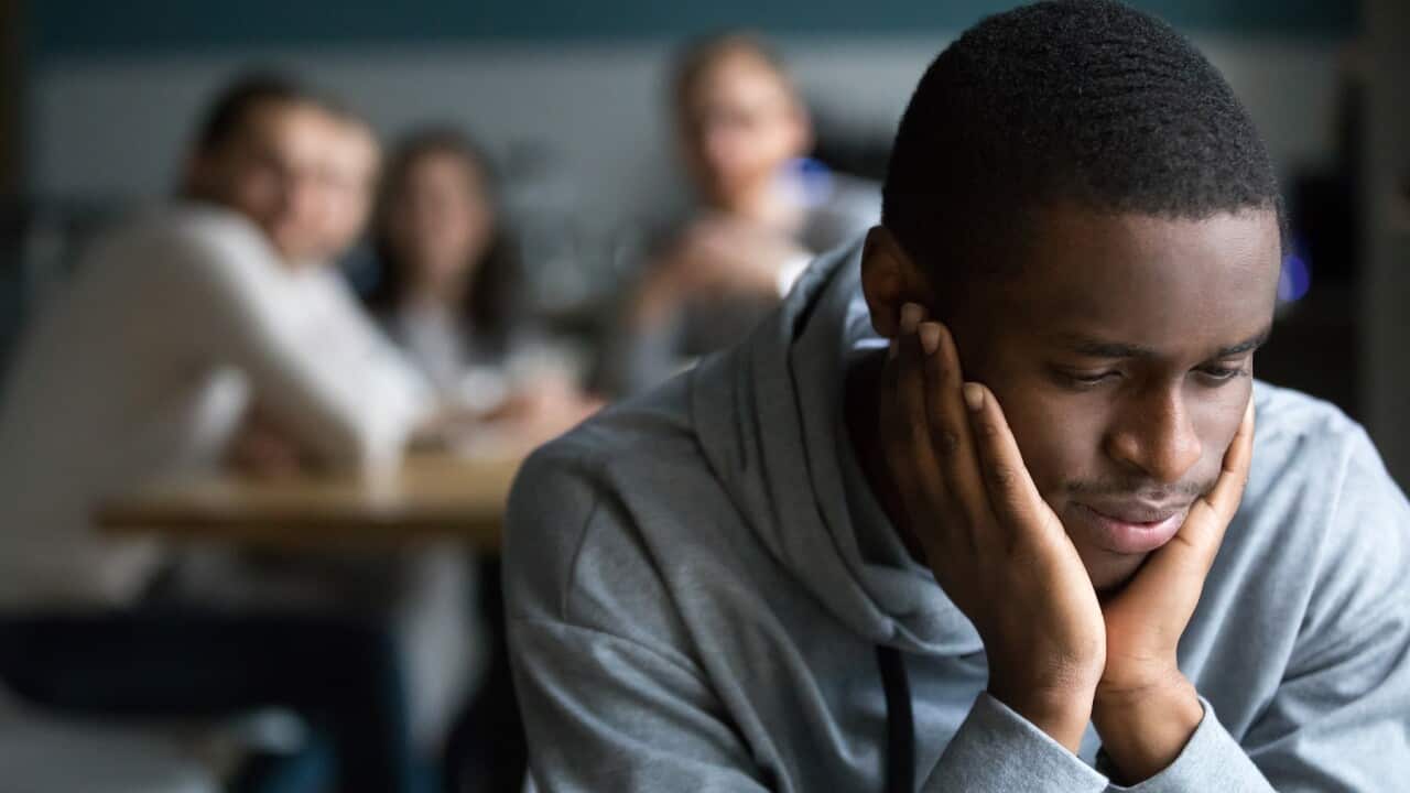 Black guy sit alone in cafe suffering from racial discrimination