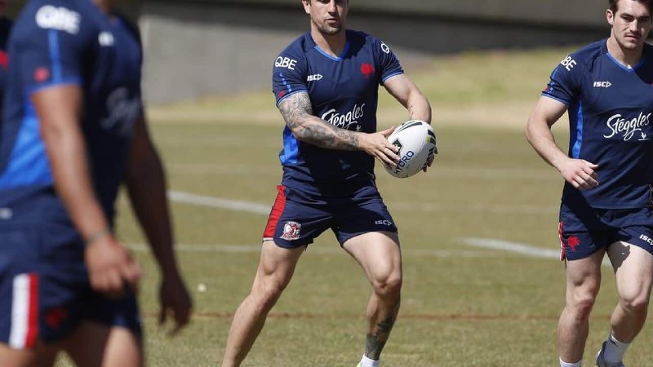Mitchell Pearce (centre) handles the ball during a training session