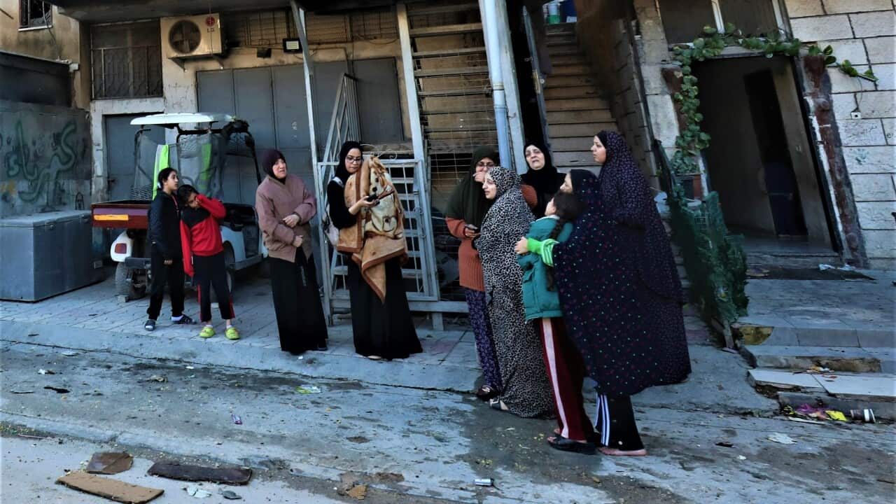 Palestinians leave their damaged houses following a raid at Al Nur Shams refugee camp near the West Bank town of Tulkarem, 26 December 2023