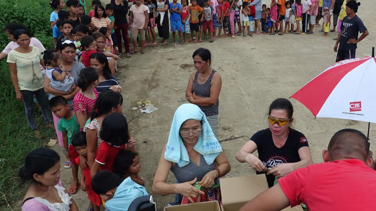 Filipino villagers queue during a relief goods distribution in the earthquake-hit town in Mindanao