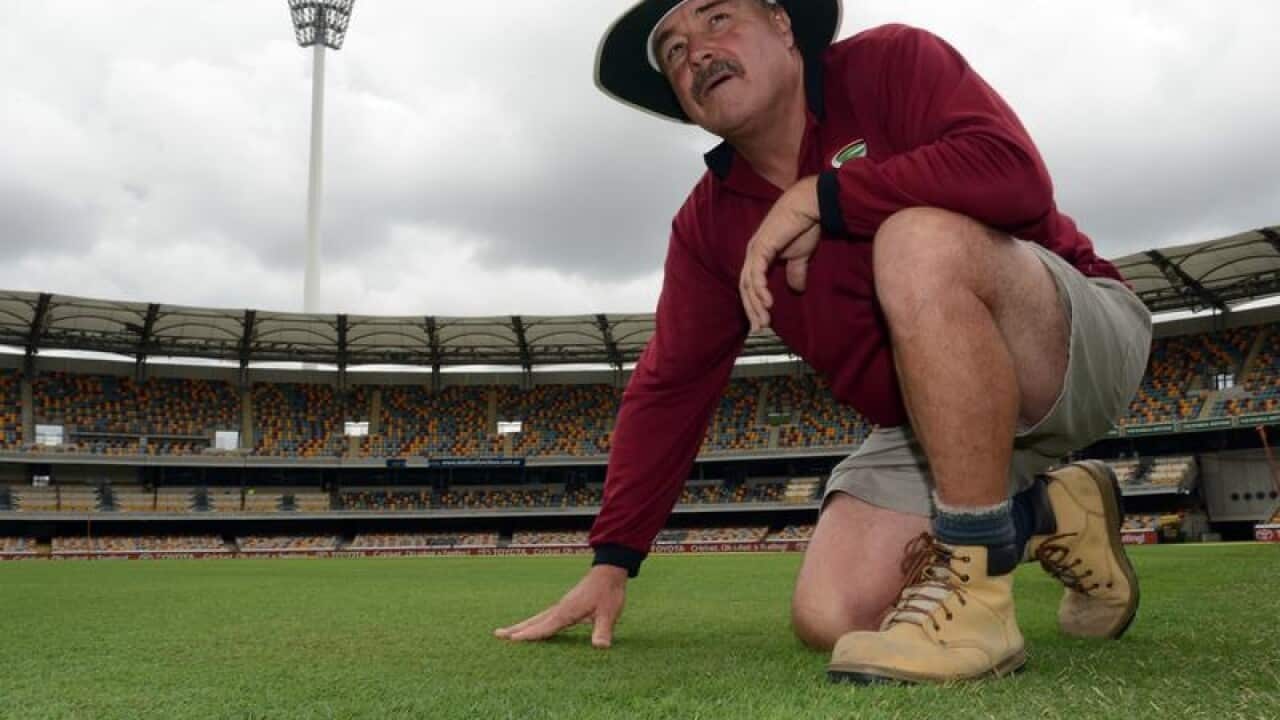 Kevin Mitchell touches the grass at the Gabba