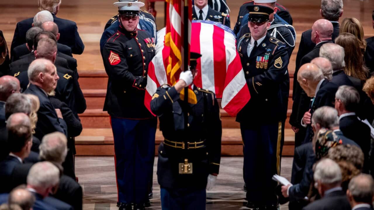 Members of the Honour Guard carry the flag-draped casket of former President George HW Bush