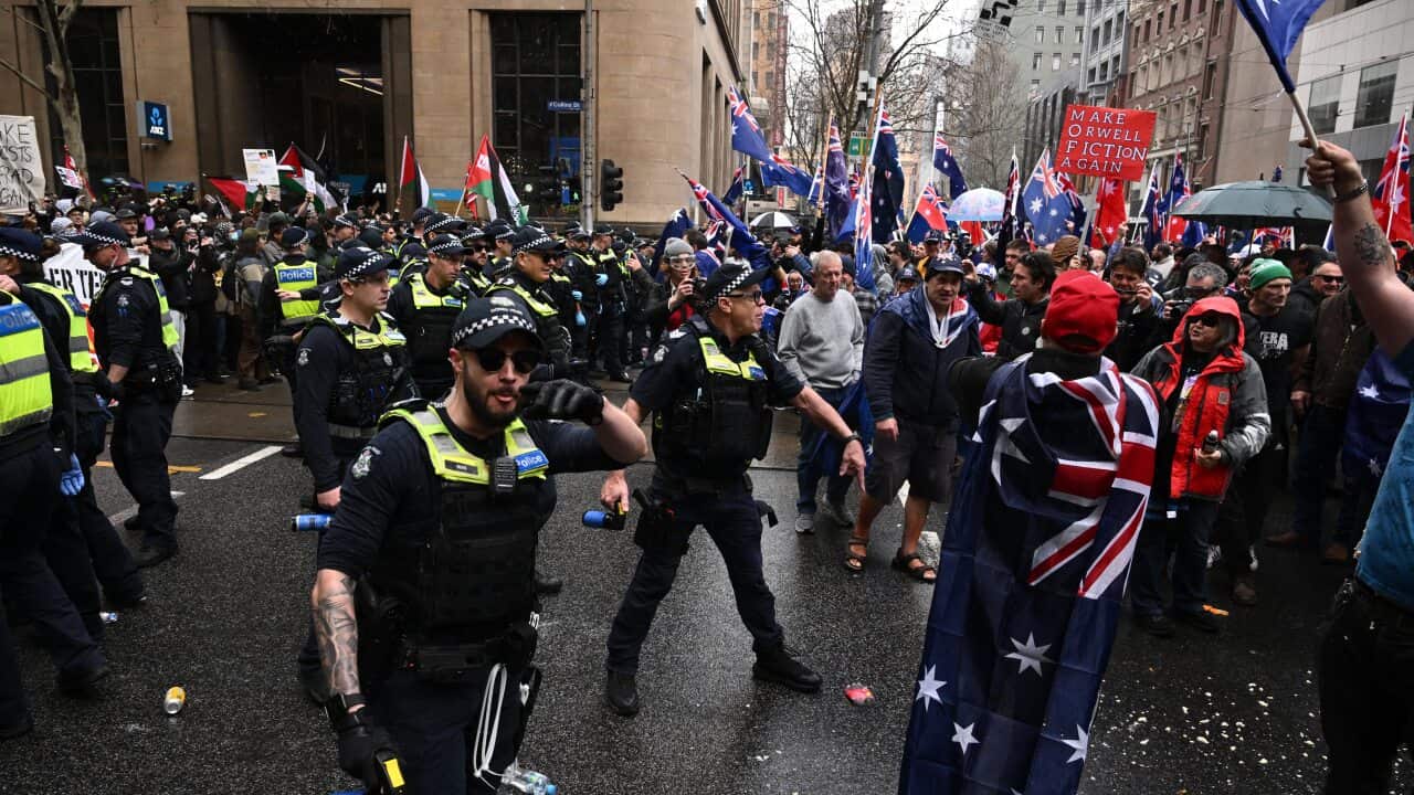 Protesters and police on a busy street.