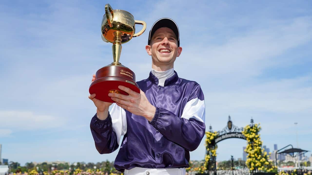 Jockey Jye McNeil holds the Lexus Melbourne Cup after riding Twilight Payment to victory