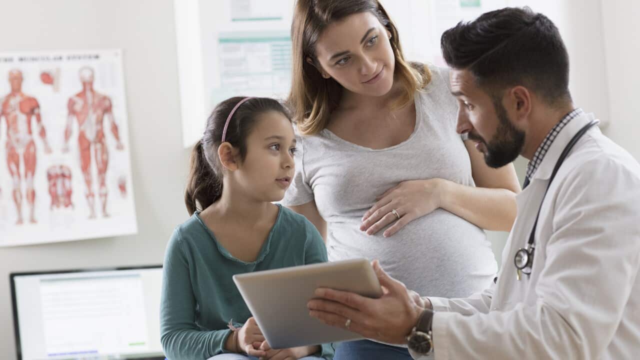 Pregnant woman takes daughter to doctor's examination