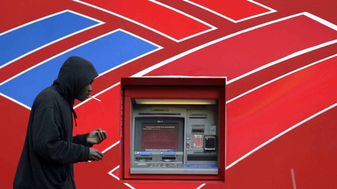 A man walks past an ATM outside the Bank of America headquarters.