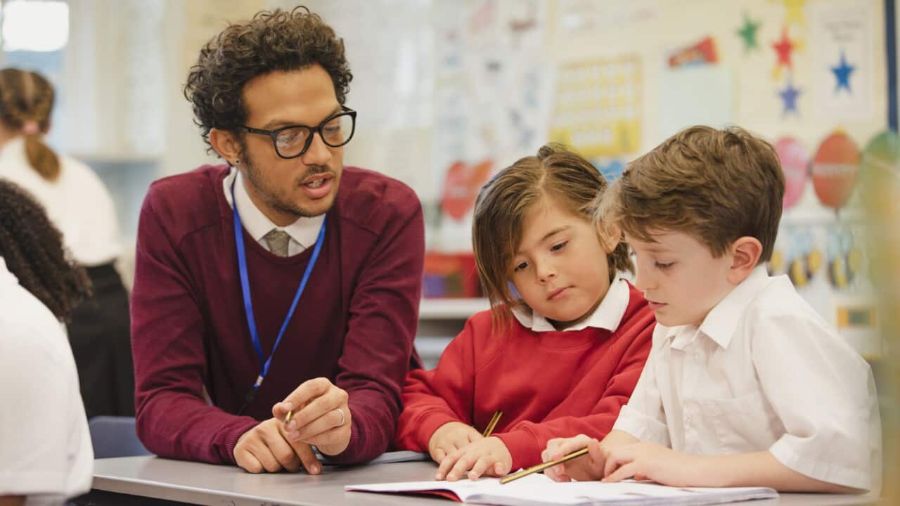 Schoolboys Work with their Teacher in Elementary Class