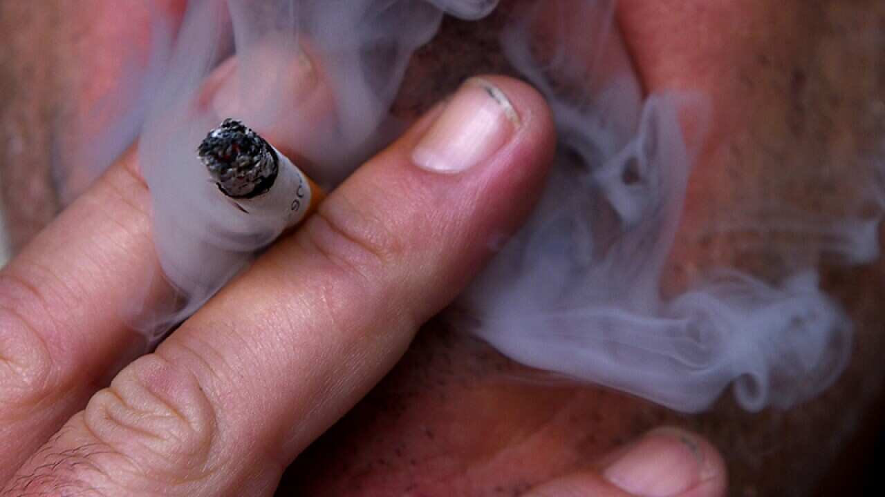 A man pictured lighting a cigarette in Canberra