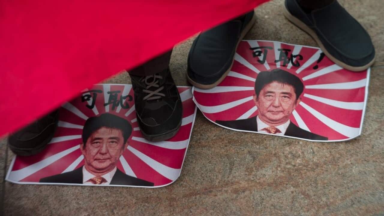 Activists with the Action Committee for Defending Diaoyu Islands step on Japan's Rising Sun flags