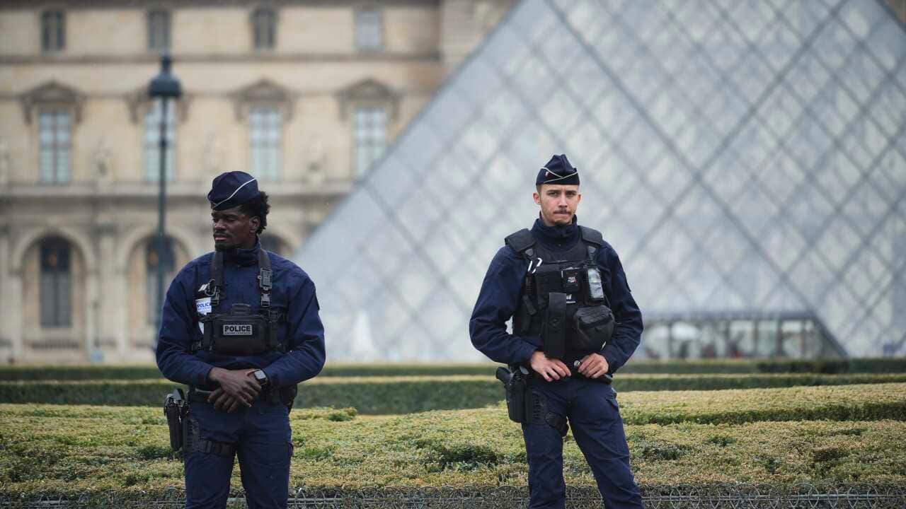 Police stand guard outside the Louvre museum in Paris