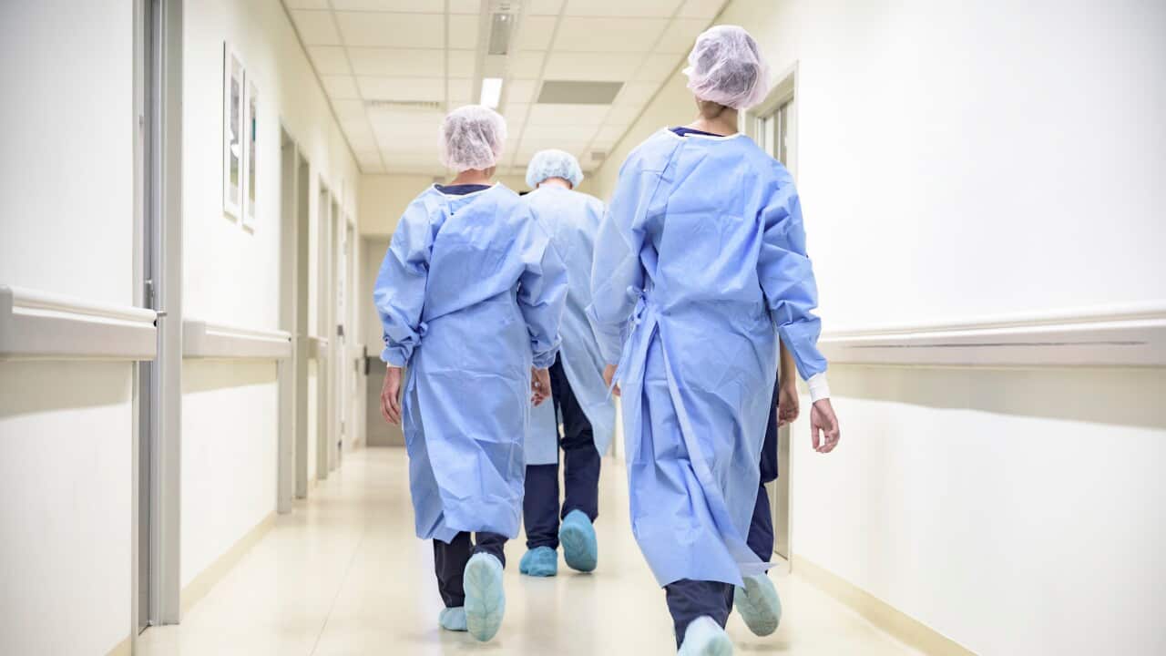 A group of hospital staff in scrubs walking through a corridor