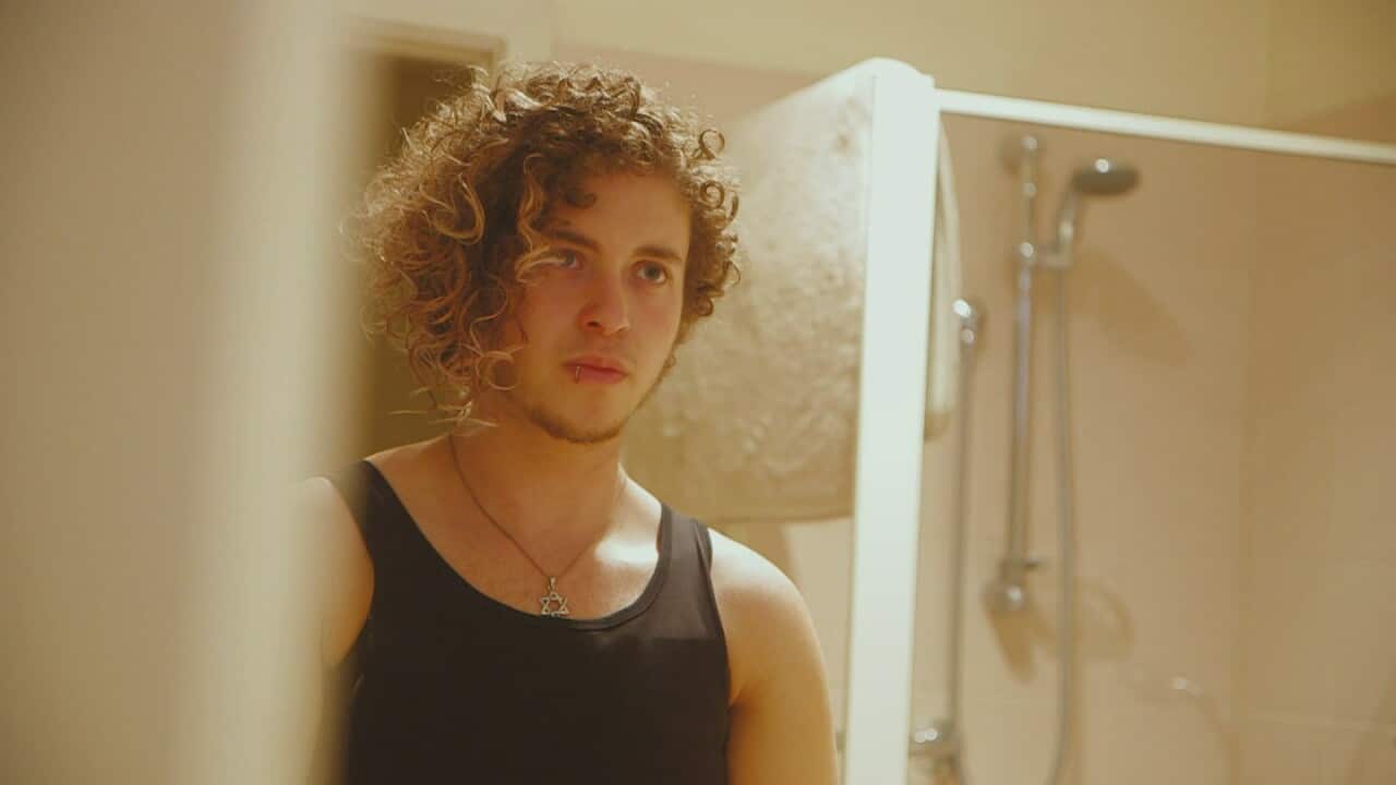 Nevo Zisin looks in mirror