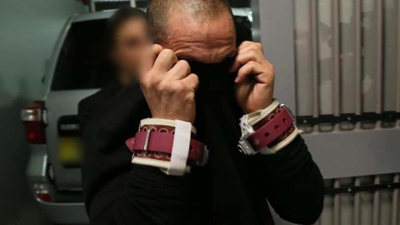 AFP officers arrest a man after being extradited from Dubai.