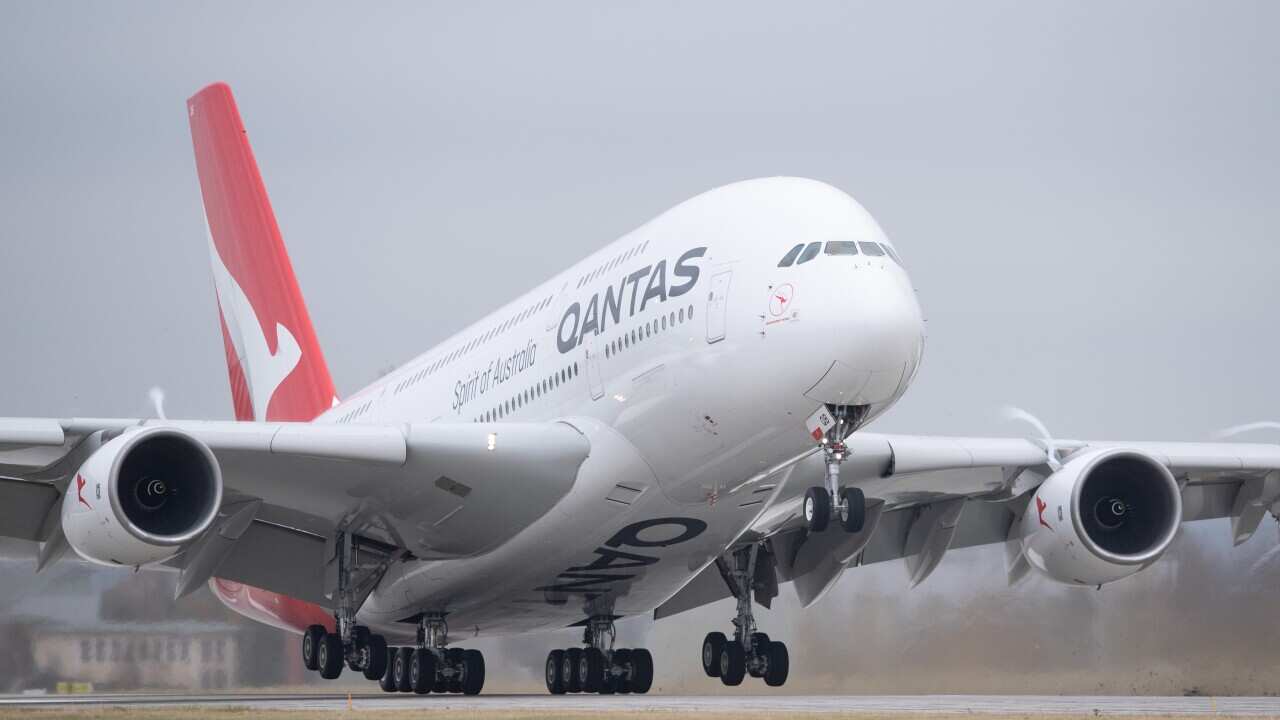 A Qantas aircraft landing on a tarmac.