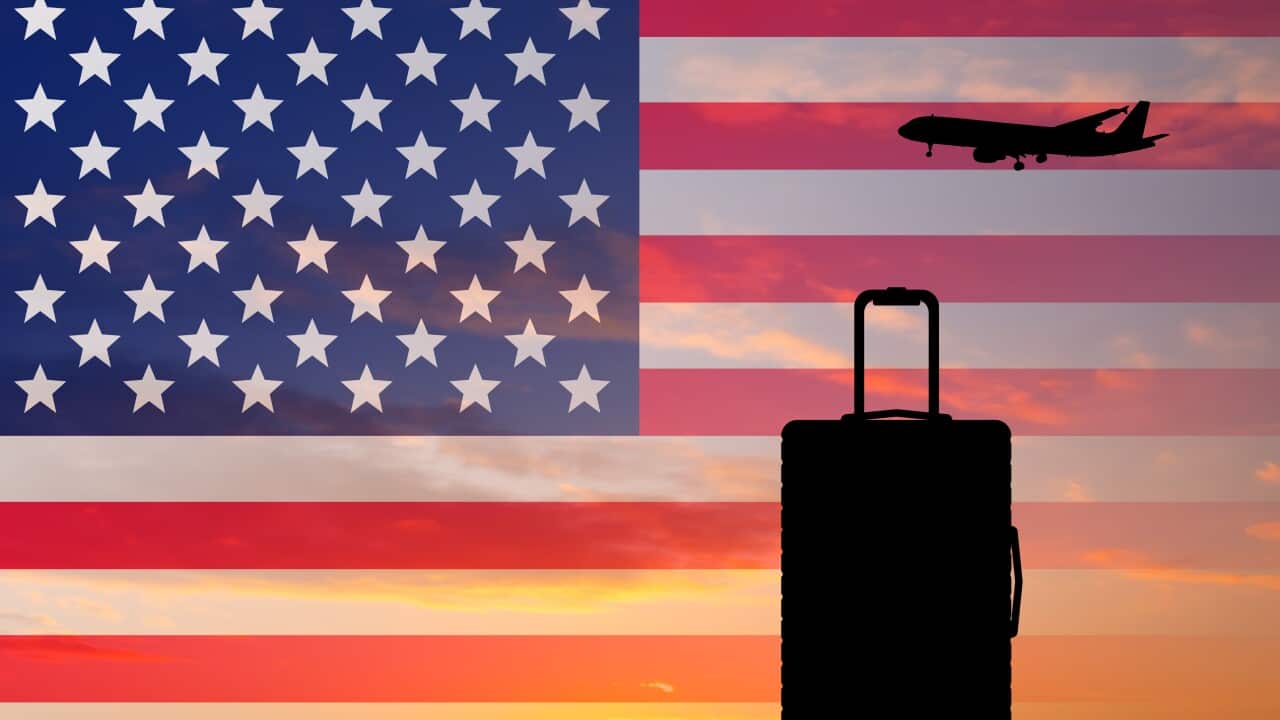 Suitcase and airplane against the background of the US flag