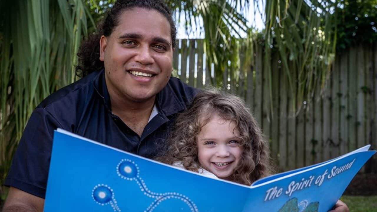 Aboriginal artist Davinder Hart, with daughter reading the Spirit of Sound.