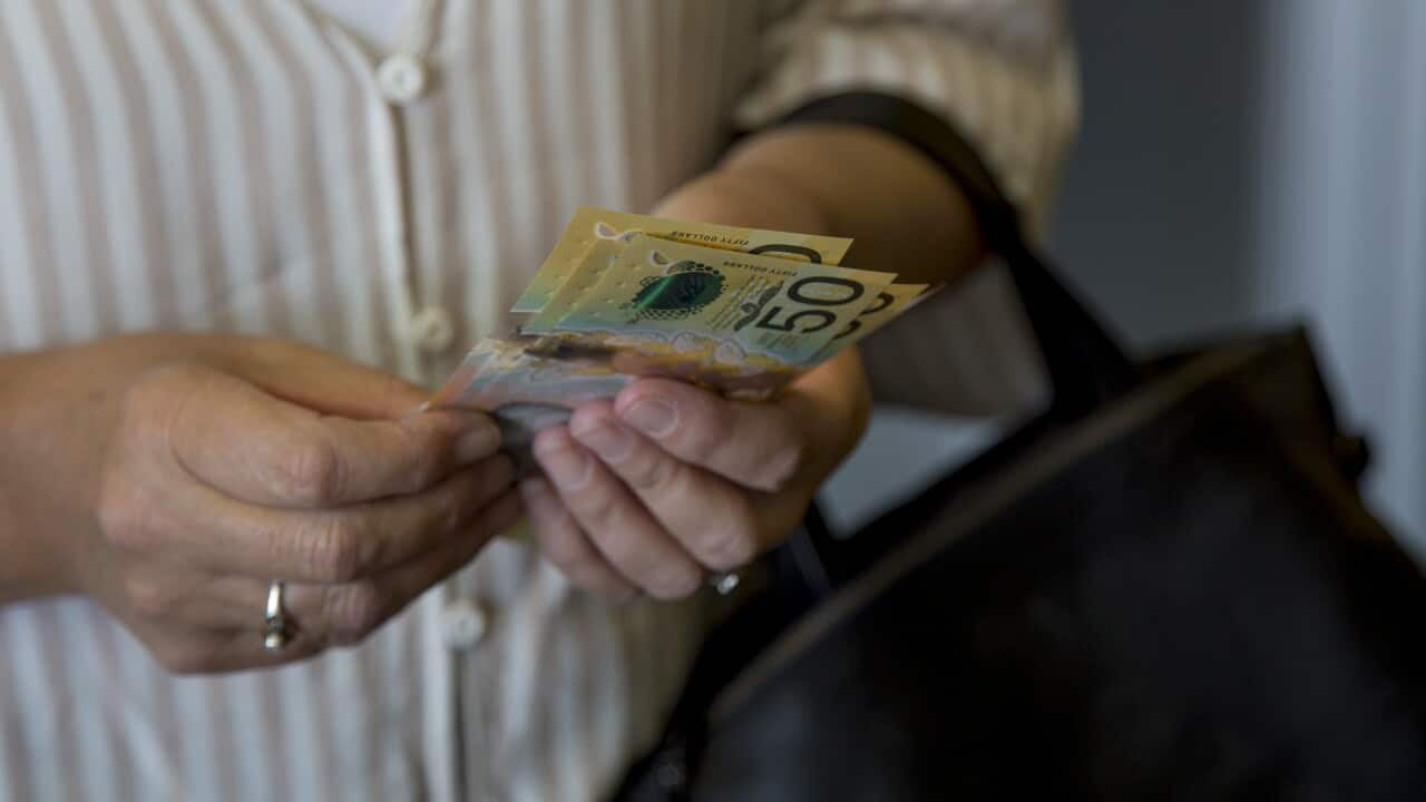A lady holding Australian currency