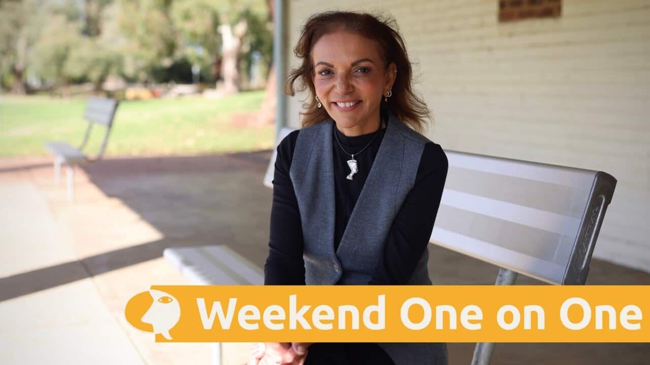 Anne Aly sitting on a park bench