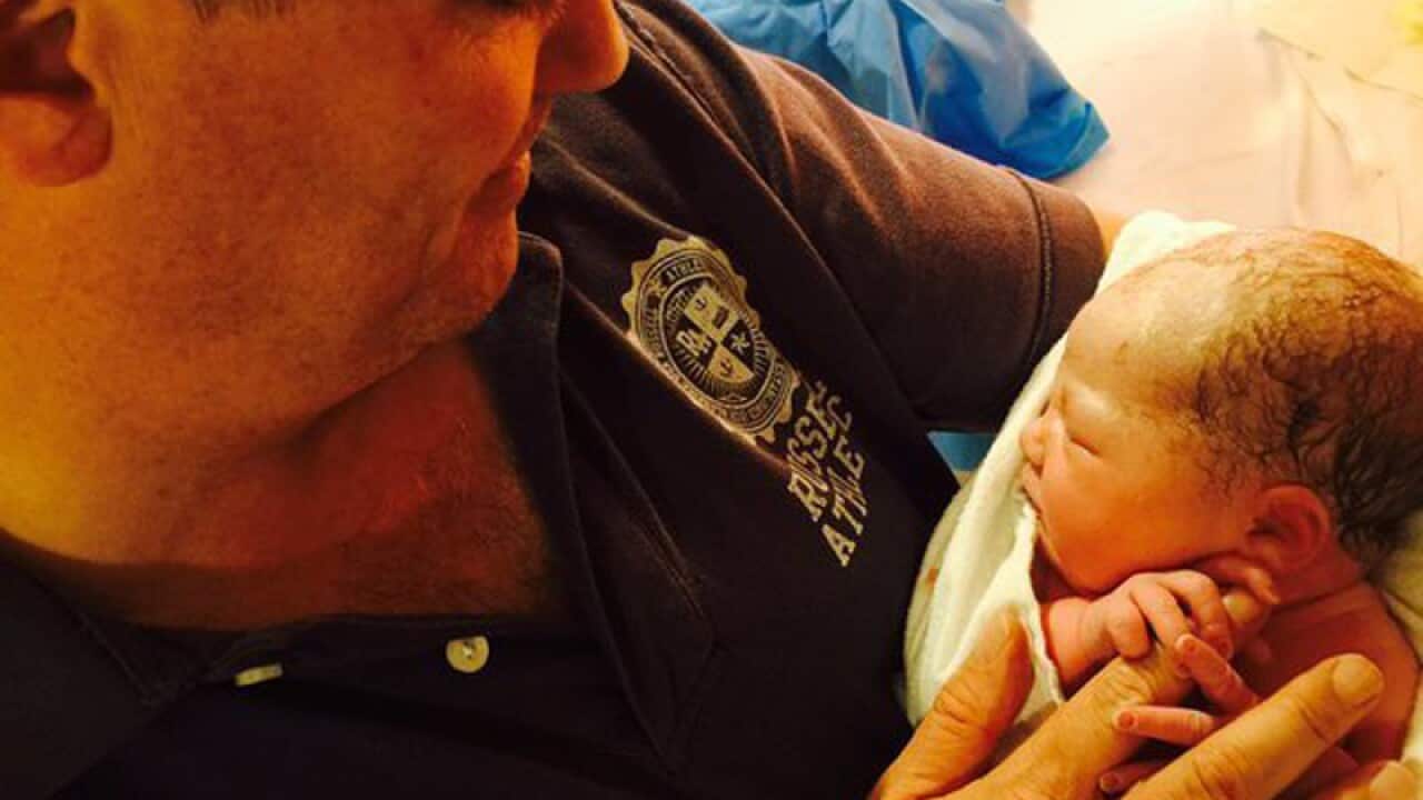 Finance Minister Mathias Cormann holding his new baby girl