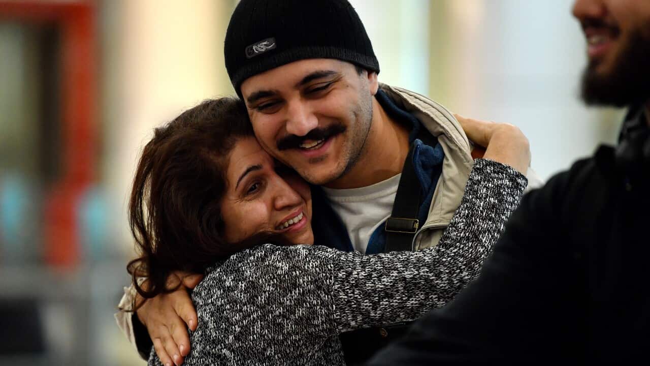 People embrace as Australian nationals arrive on a repatriation flight at Sydney International Airport