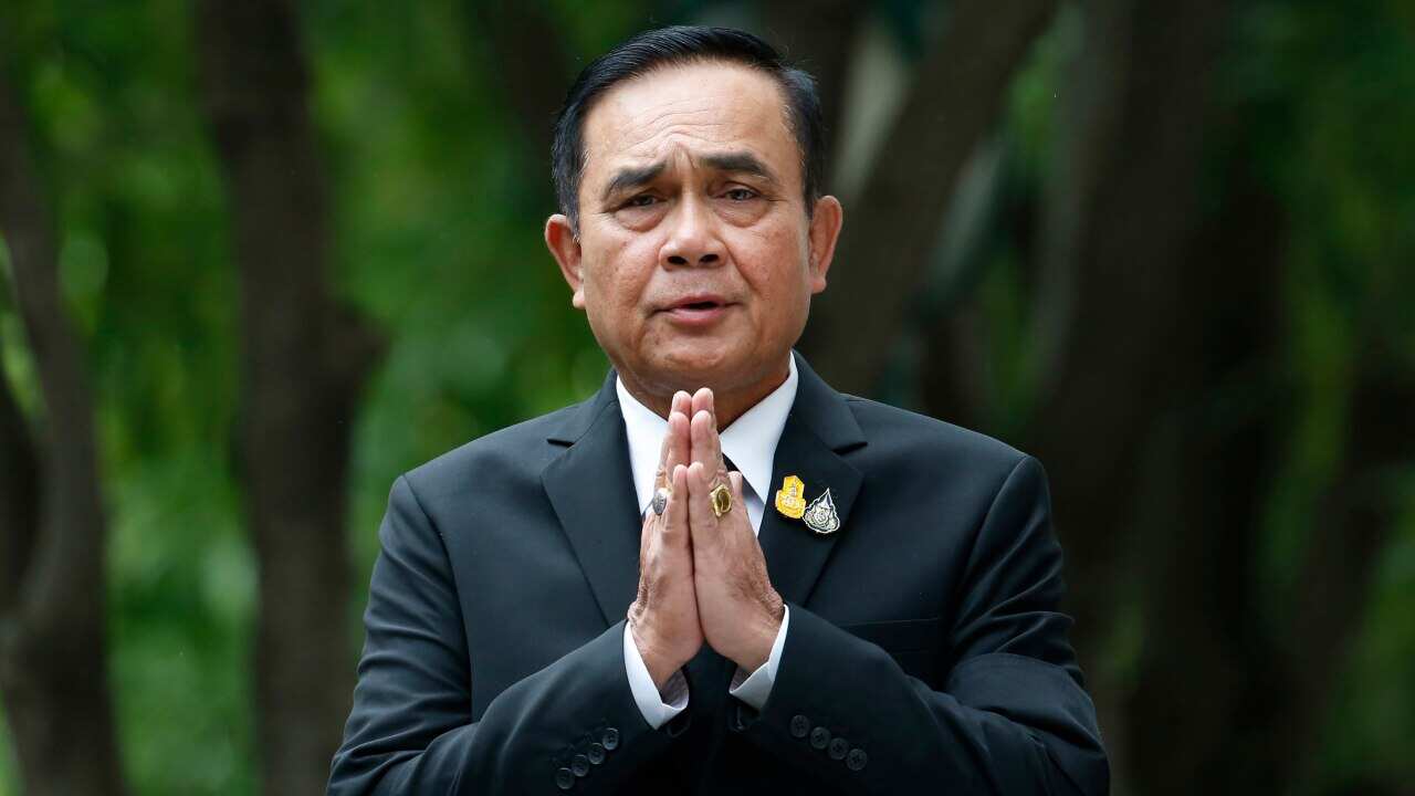 Thailand's Prime Minister Prayuth Chan-ocha gives the traditional greeting, or "wai," as he talks to reporters before meeting at government house in Bangkok.
