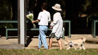 Women laying flowers at the scene of a stabbing