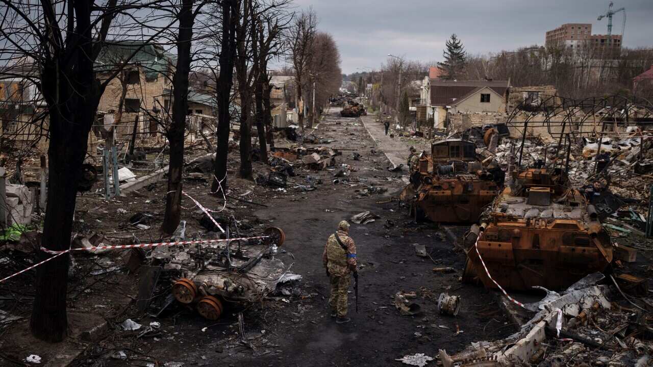A Ukrainian serviceman walks amid destroyed Russian tanks in Bucha, on the outskirts of Kyiv, Ukraine.