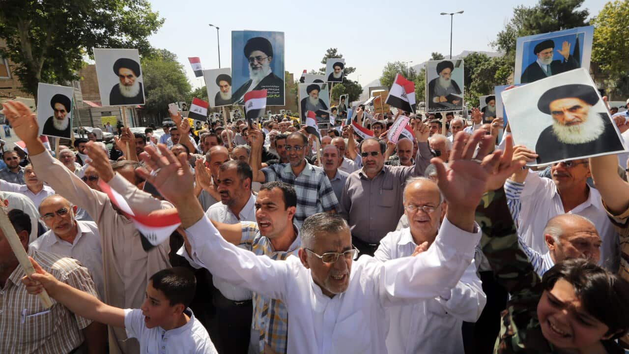 Iraqis living in Iran hold posters of Shiite Muslim spiritual leader Grand Ayatollah Ali al-Sistani and the Iranian supreme leader Ayatollah Ali Khamenei in southern Tehran on June 20, 2014, against the offensive by Sunni Arab jihadists in Iraq. (Getty)