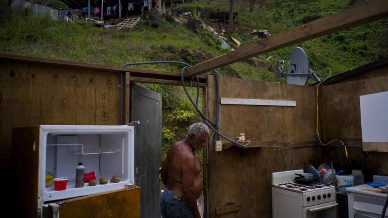A man walks into a house destroyed by Hurricane Maria