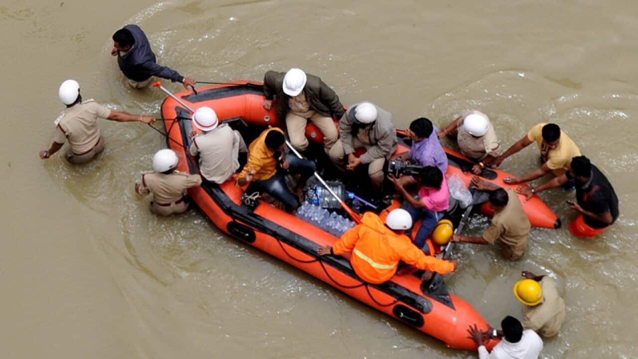 Indian Emergency Service personnel help people to reach safe area