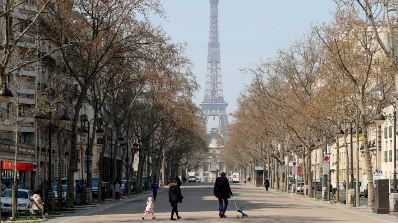 People walk near the Eiffel tower in Paris