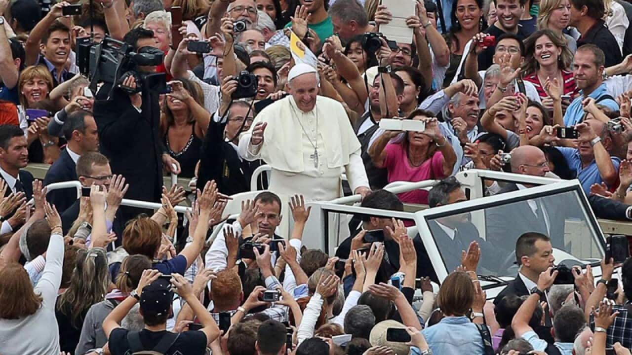 Pope Francis surrounded by a crowd at St Peter's Square