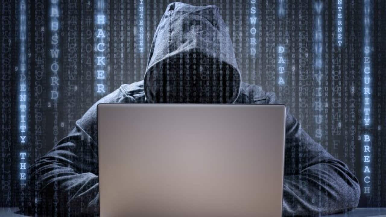 Computer hacker stealing data from a laptop