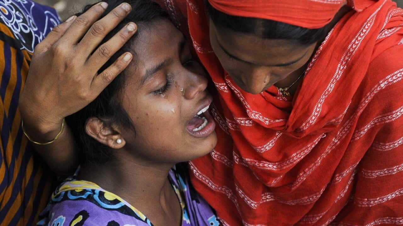 A Bangladeshi woman cries at the site of a building collapse.