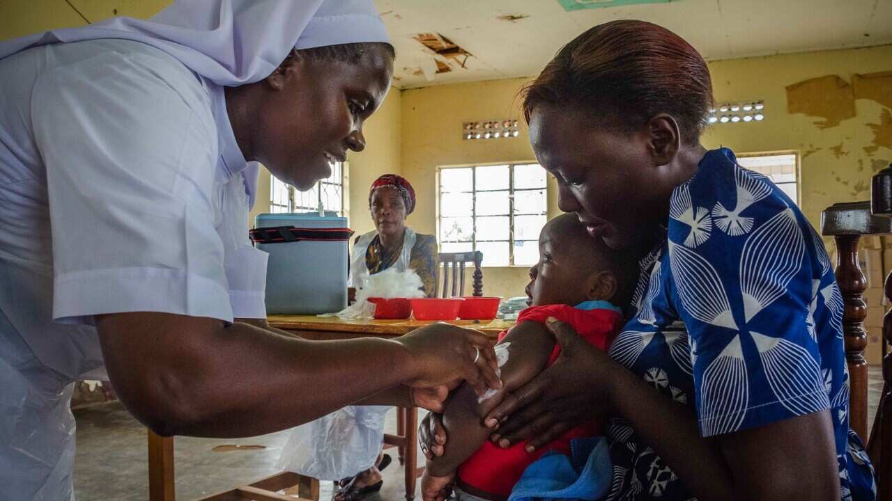 child receives an injection during the vaccination campaign against measles, rubella and polio in Uganda