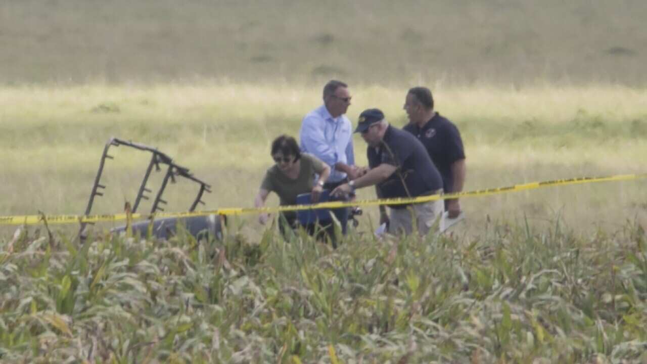 The partial frame of a hot air balloon is visible above a crop field at the scene in a field near Lockhart, Texas where a hot air balloon carrying at least 16 people collided with power lines