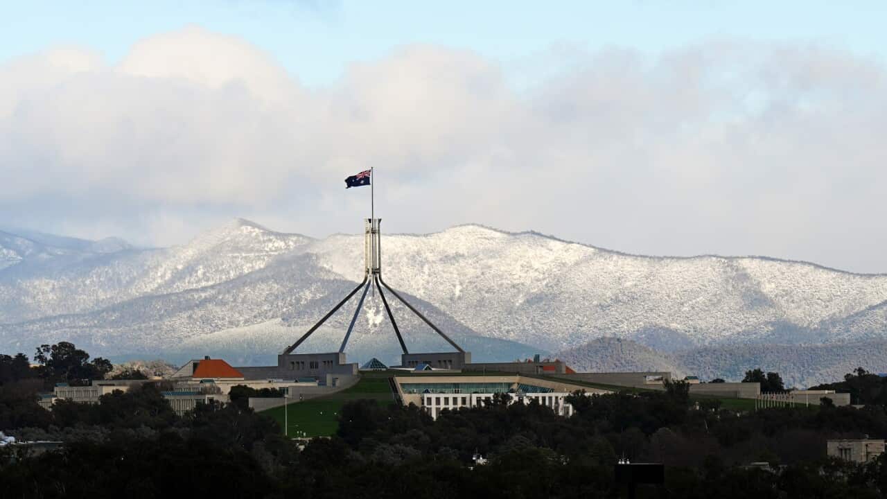 Snow covered hills are seen behind Parliament House in Canberra, Wednesday, June 1, 2022. (AAP Image/Lukas Coch) NO ARCHIVING