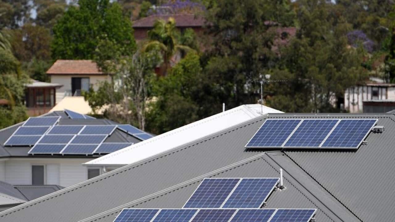 Solar panels are seen on the rooftops of houses.