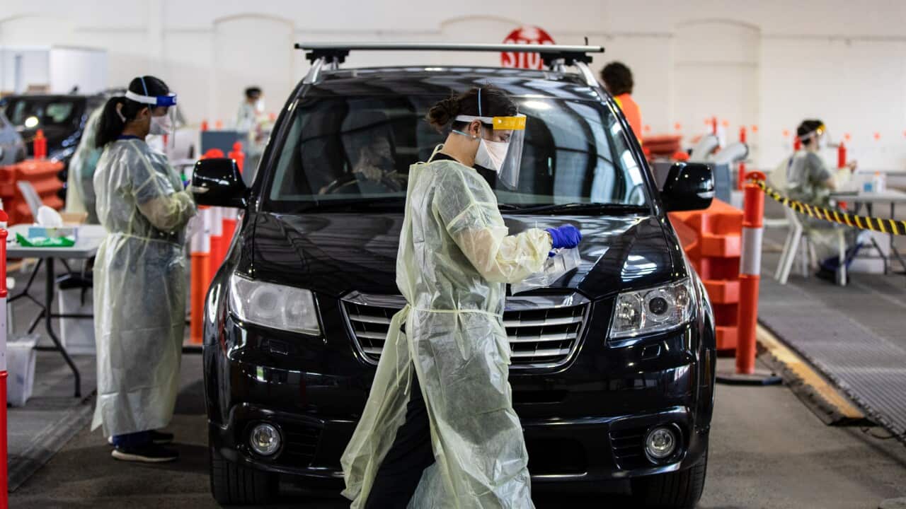 Healthcare workers are seen at a COVID-19 testing site in Melbourne