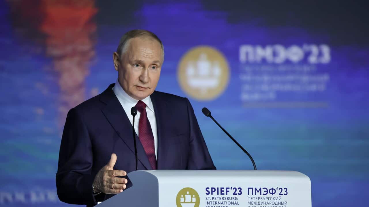 Russian President Vladimir Putin speaks at a lectern.