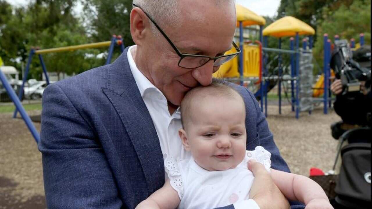 SA Premier Jay Weatherill holds baby Charlotte while campaigning.