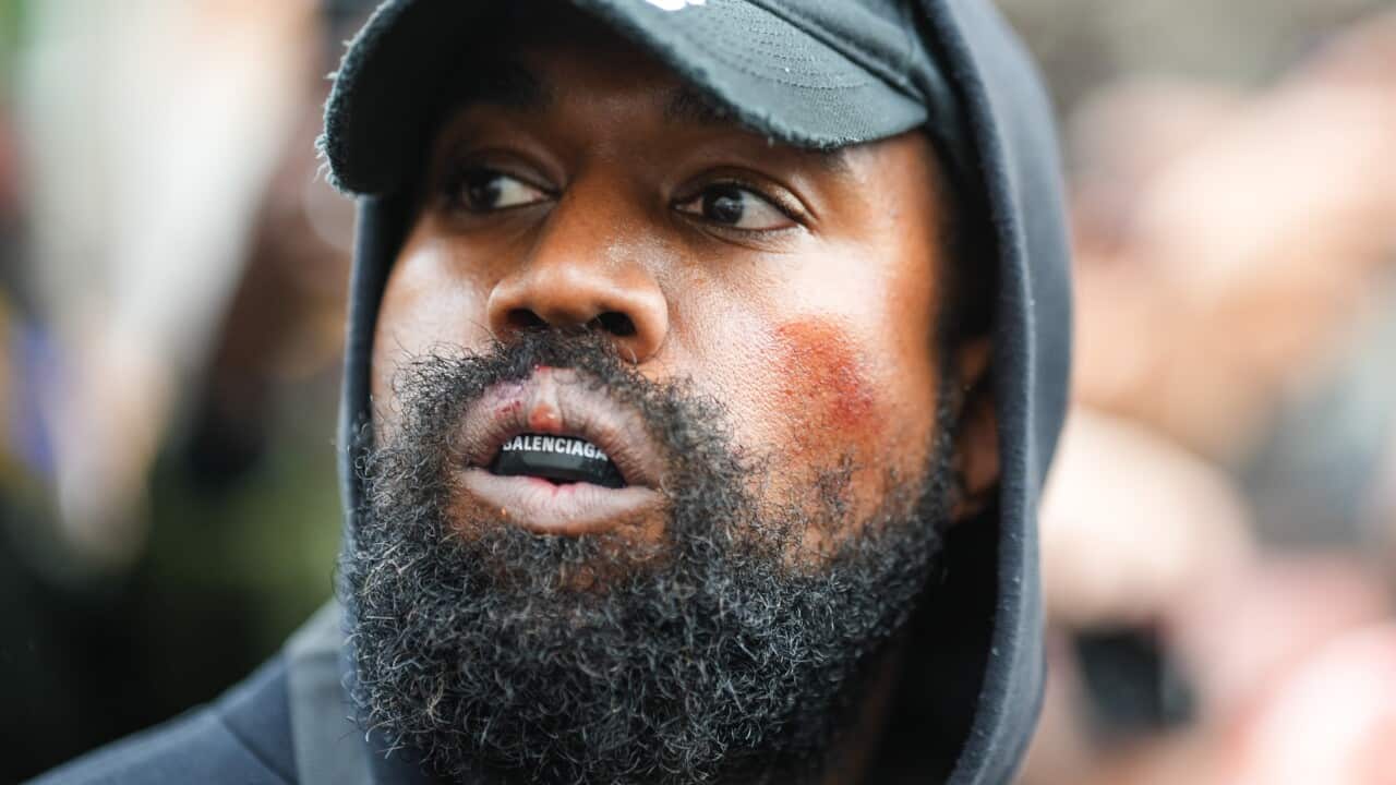 A man wearing a hoodie, cap, and mouthguard.