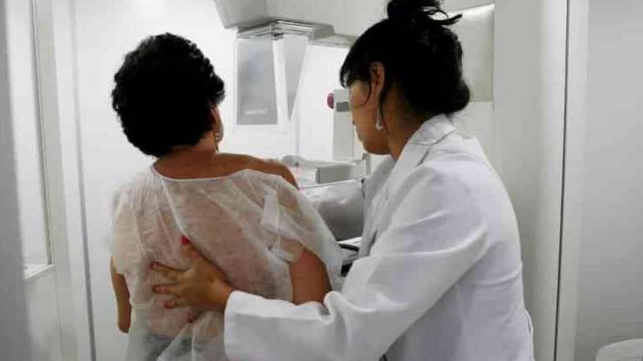 A woman undergoes a mammogram.