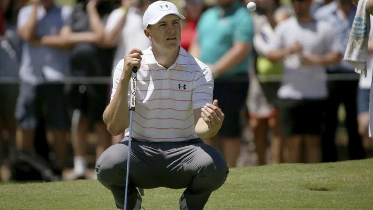 Jordan Spieth of the U.S. tosses his ball to his caddie on 2nd green.