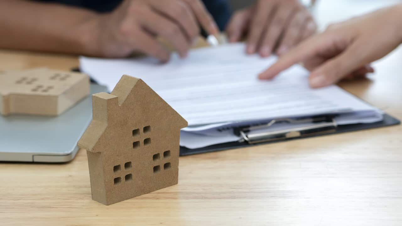 Customer signing a real estate contract in real estate agency.